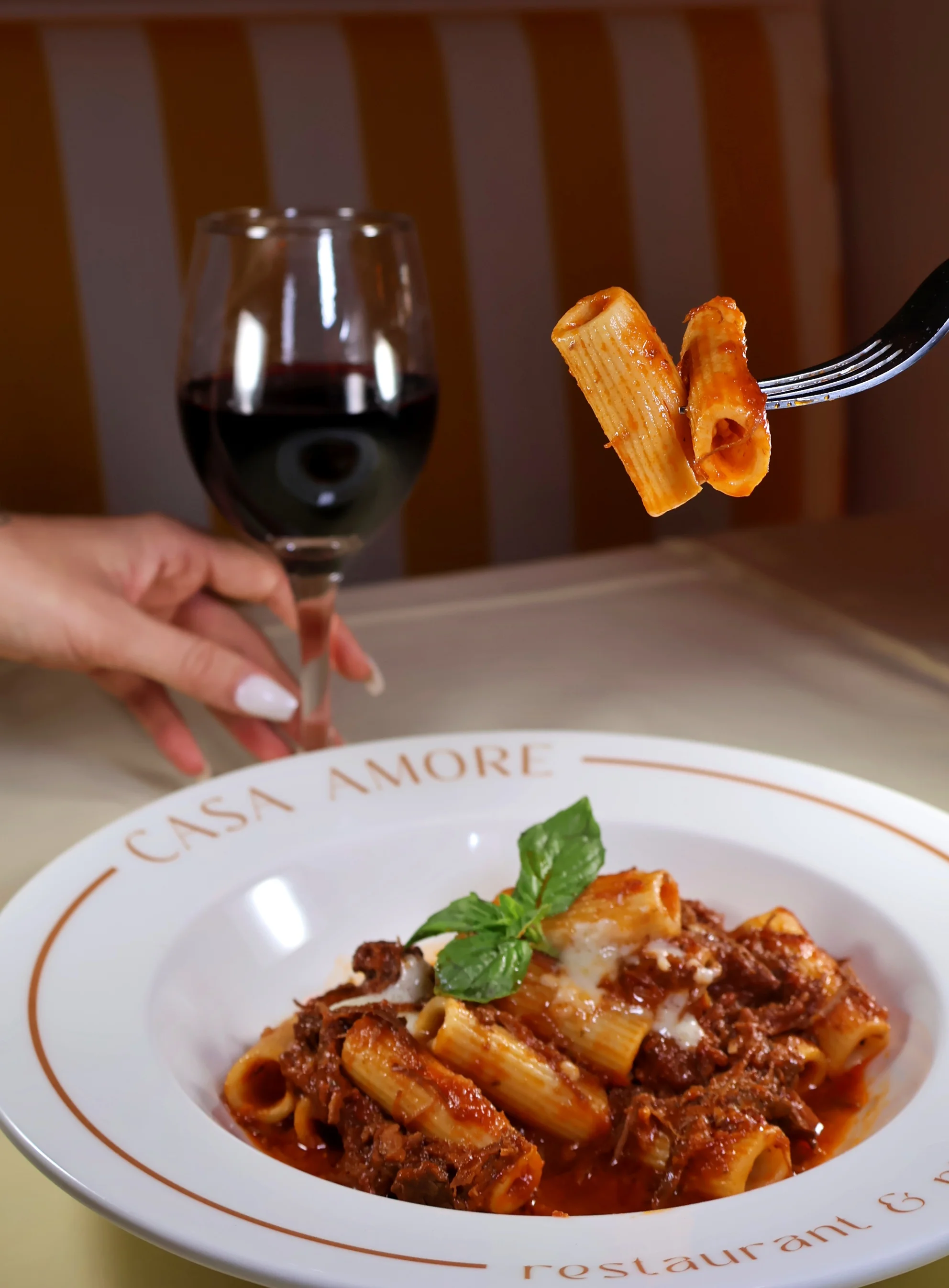 Plate of Italian rigatoni with meat sauce and basil