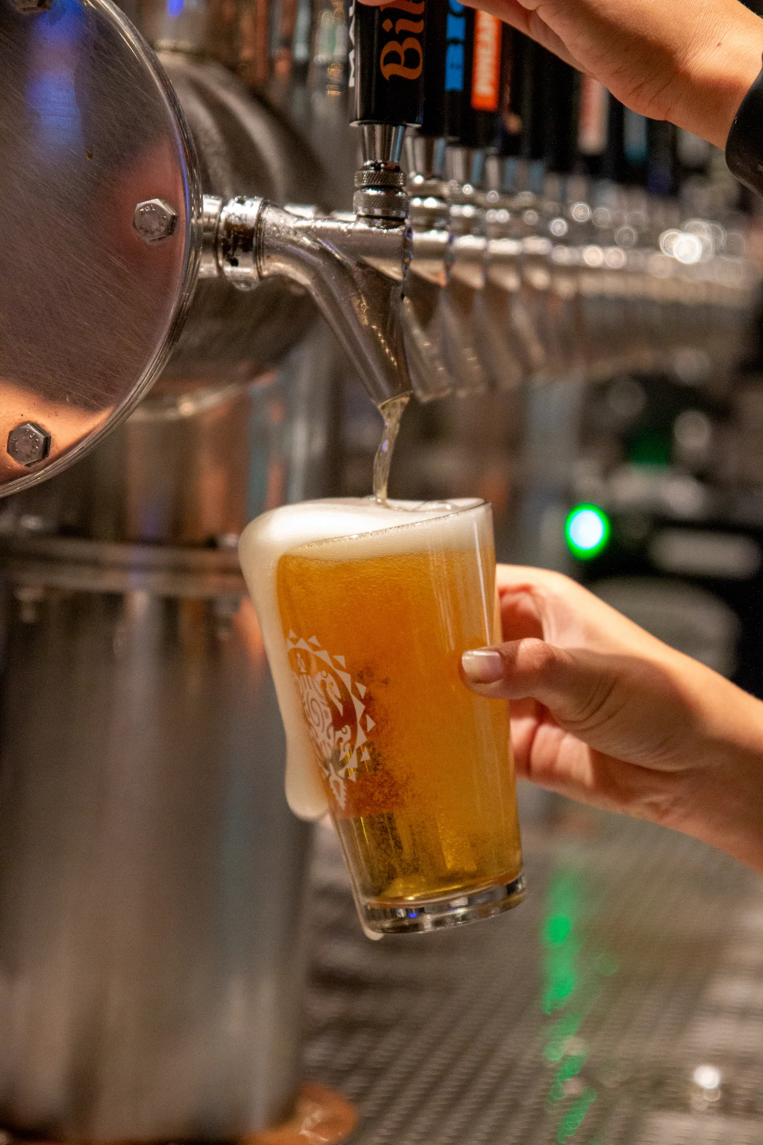 Bartender pouring craft beer into a glass at a bar