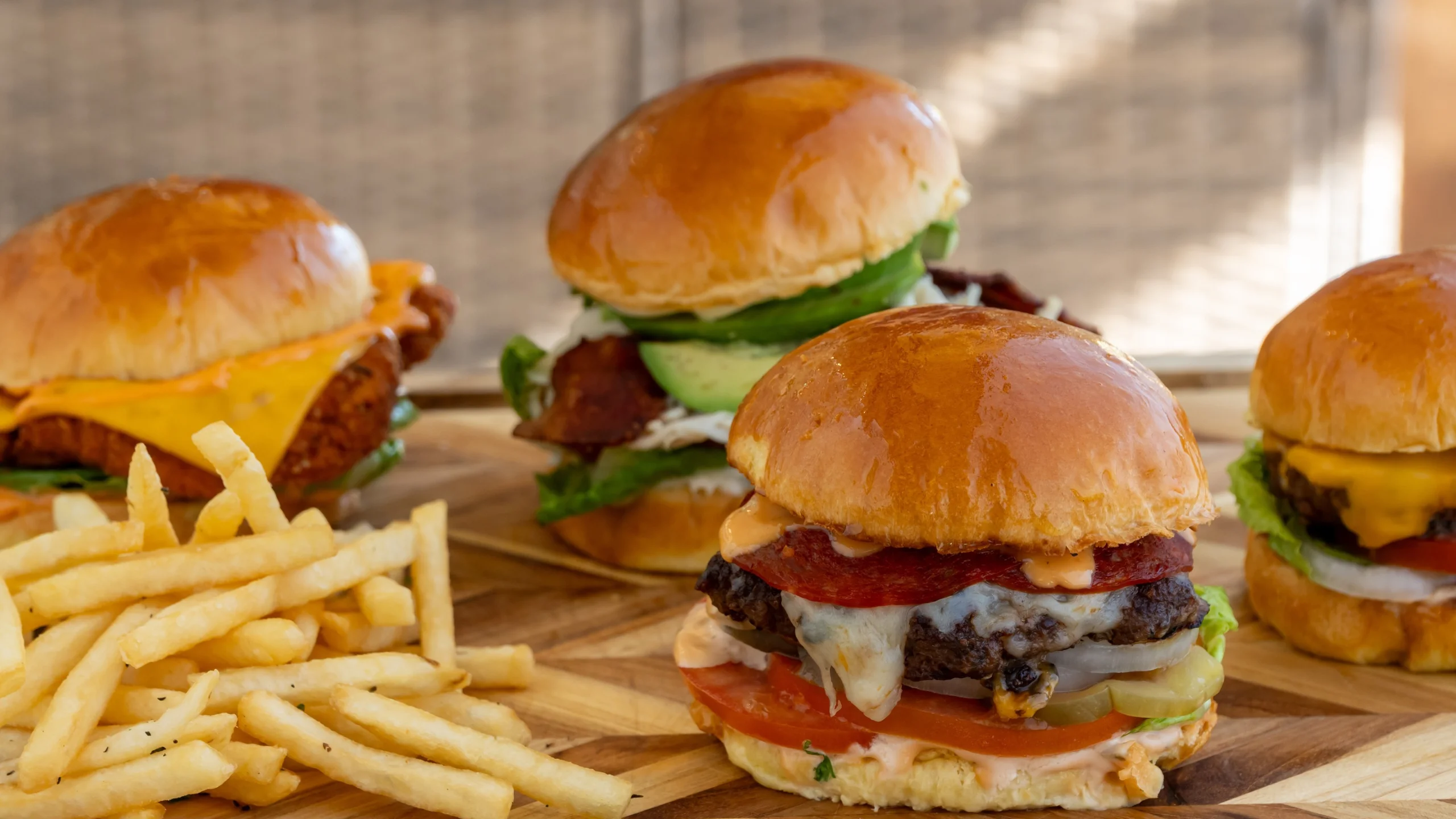 Gourmet sliders with fries on a wooden platter