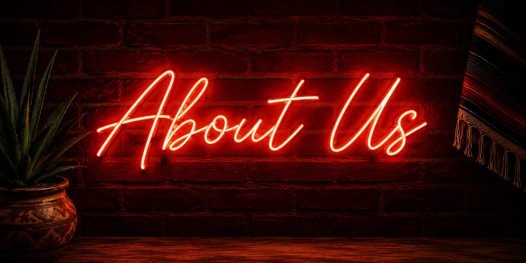 Neon sign reading 'About Us' on a brick wall