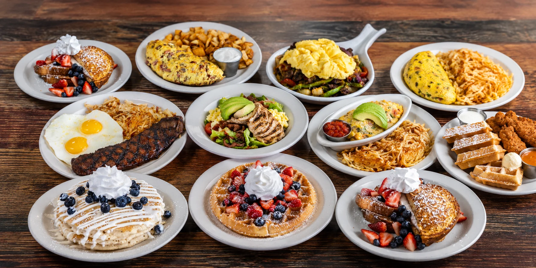 Variety of American breakfast dishes including pancakes, waffles, and omelets