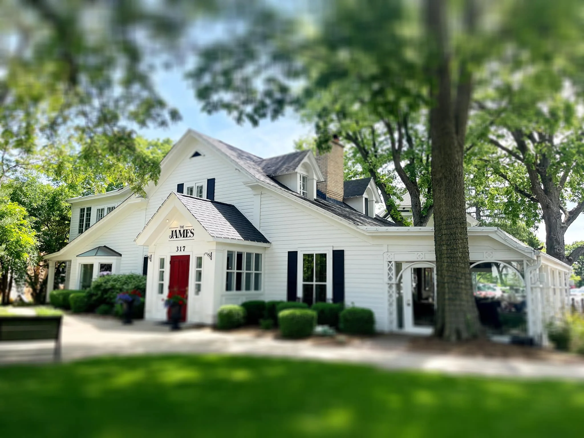 Charming restaurant exterior with white siding and red door