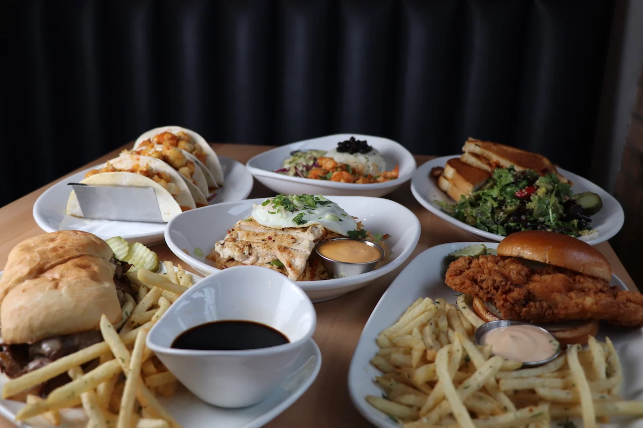 Assorted American comfort food platter with tacos, fried chicken, and salads