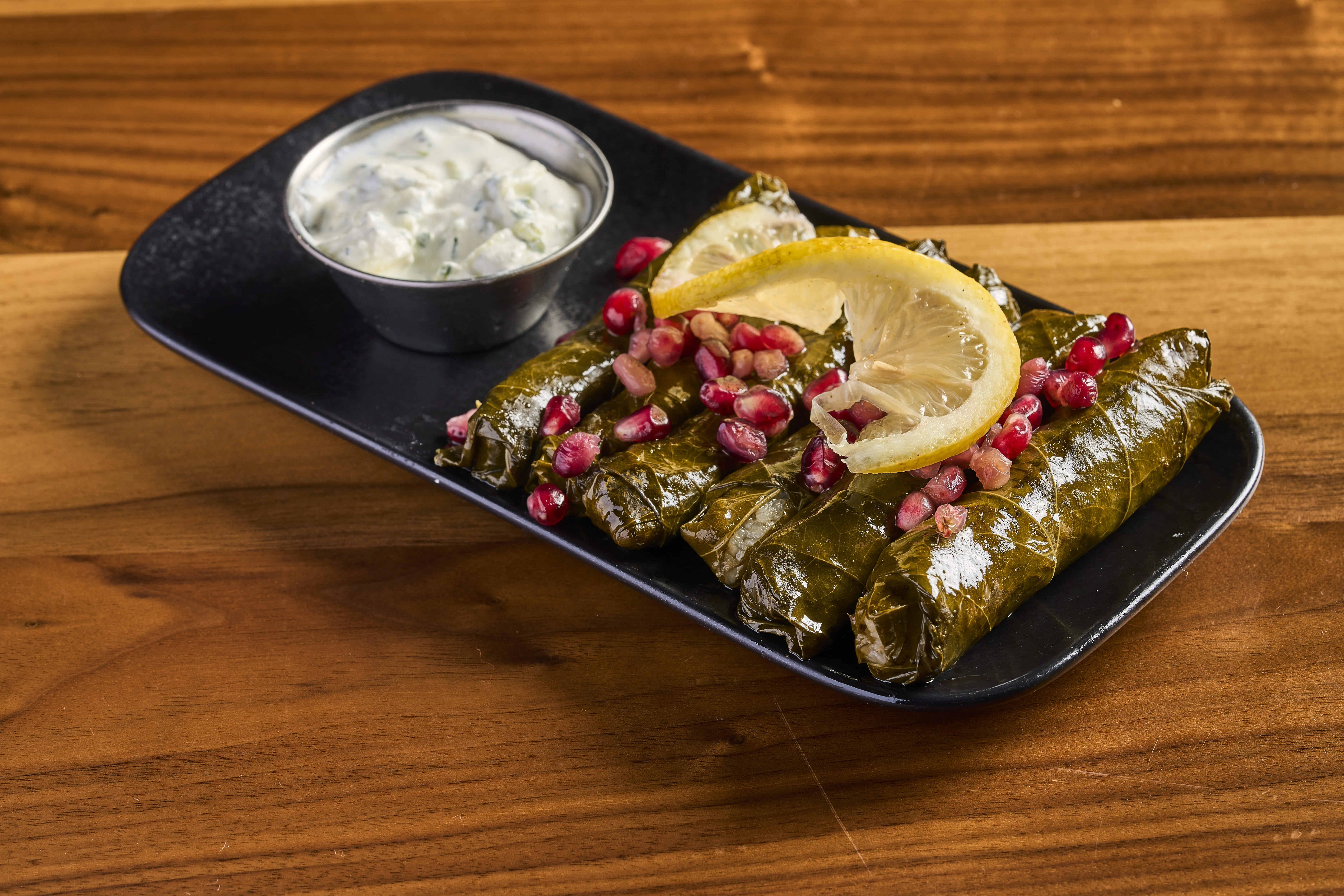 Grape leaves stuffed with seasoned rice and beef, and served with tzatziki. 