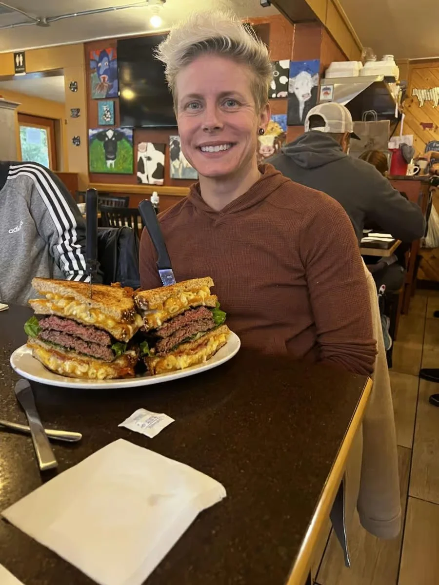 Giant mac and cheese burger stacked high in a cozy restaurant