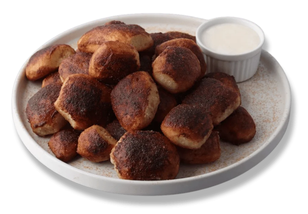 Delicious cinnamon bites drizzled with icing on a white plate.