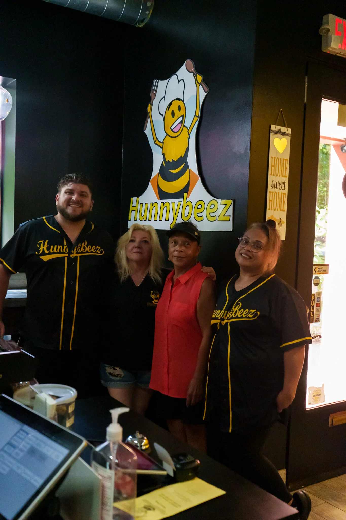 Friendly staff at Hunnybeez restaurant with a bee-themed logo