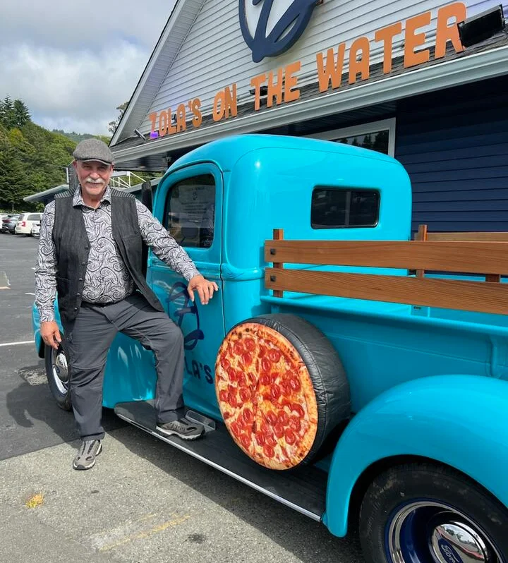 Colorful vintage truck with pizza design outside Zola's on the Water restaurant