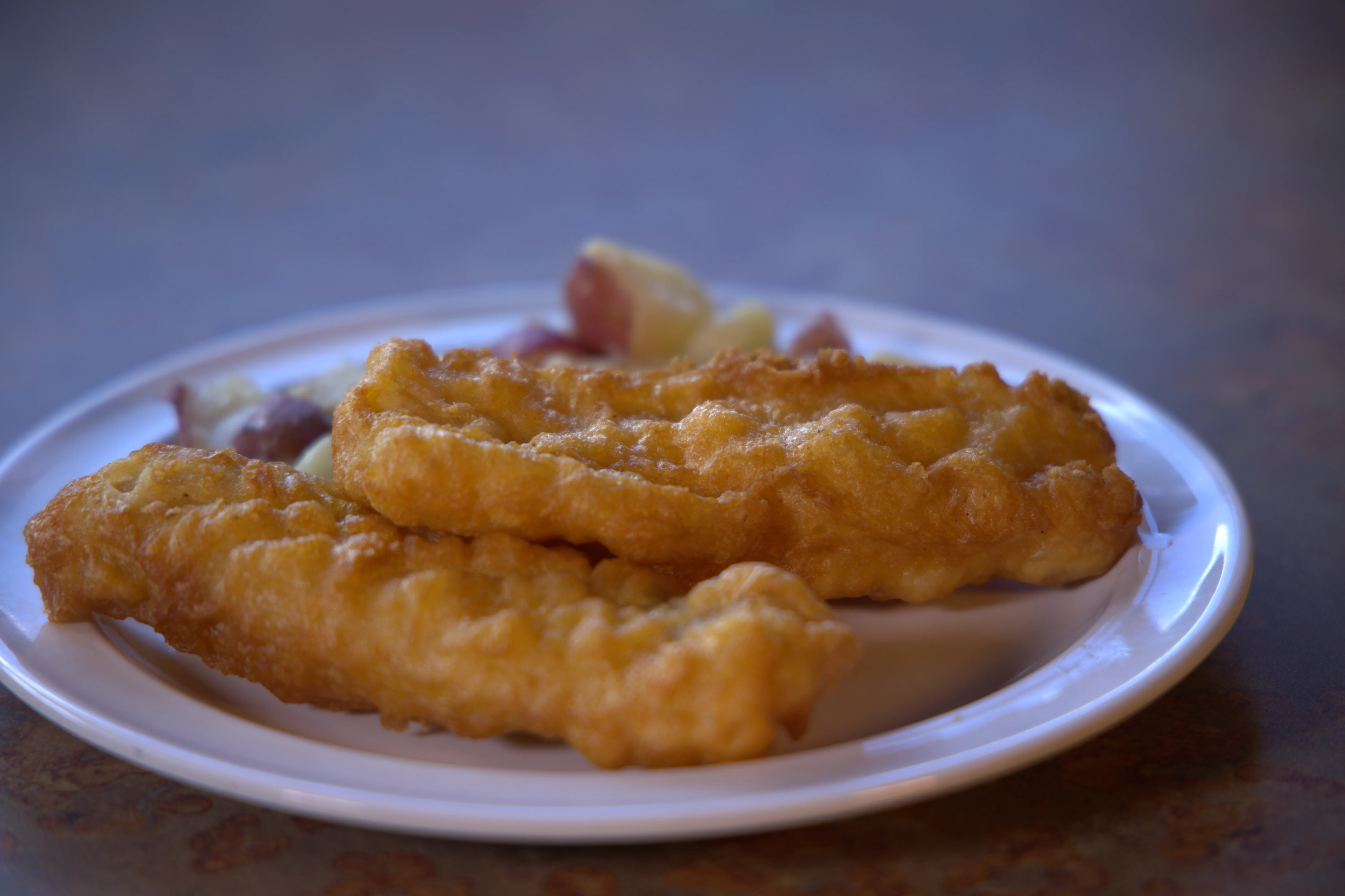 Golden fried fish fillets served with potatoes