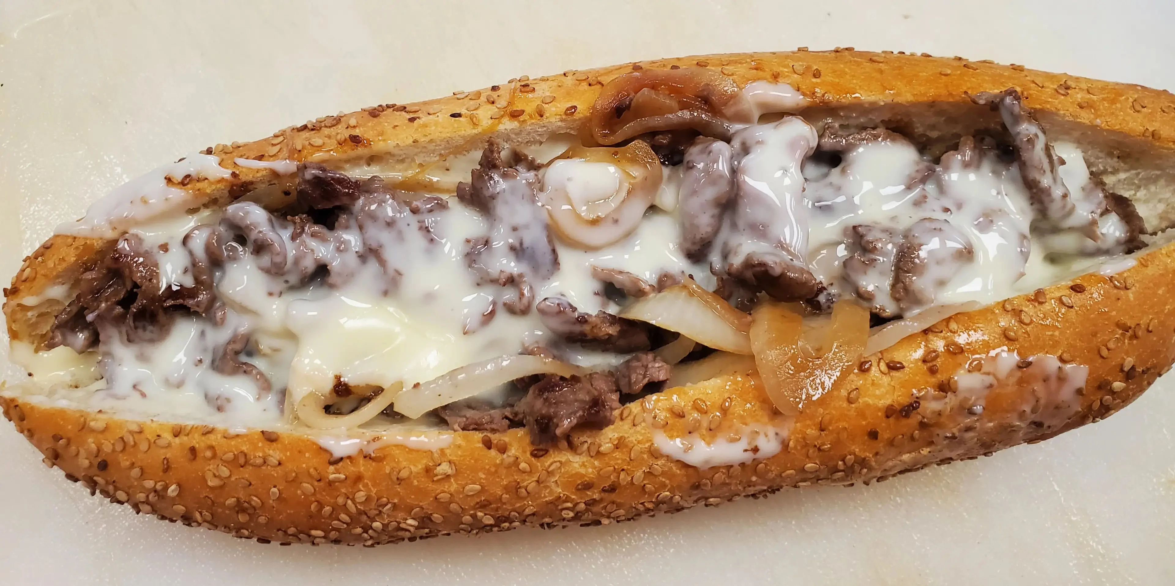 Philly cheesesteak sandwich with melted cheese and sautéed onions