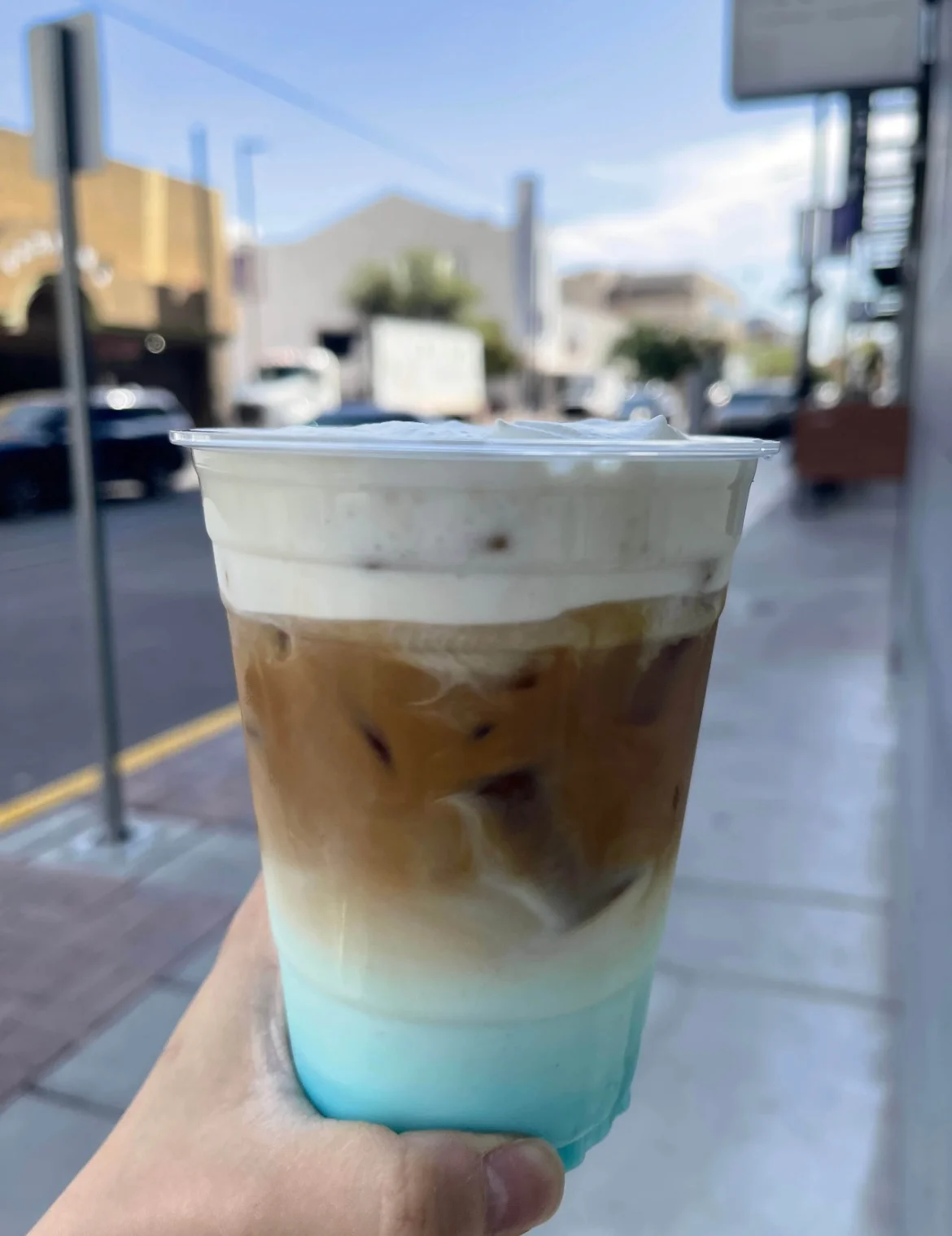 Iced coffee drink with layered colors and whipped cream