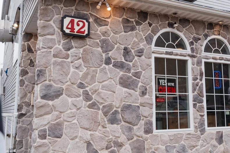 Restaurant exterior with stone wall and open sign
