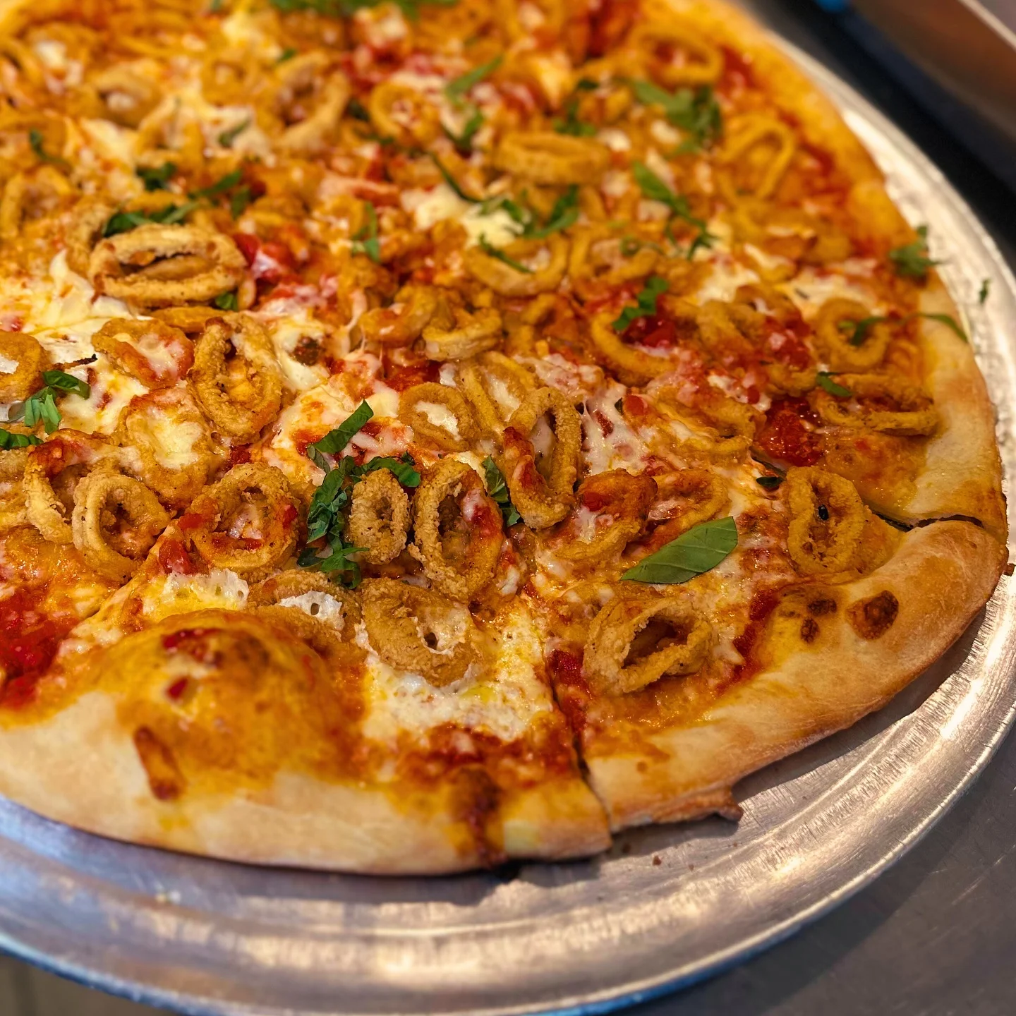 Crispy calamari pizza with fresh herbs