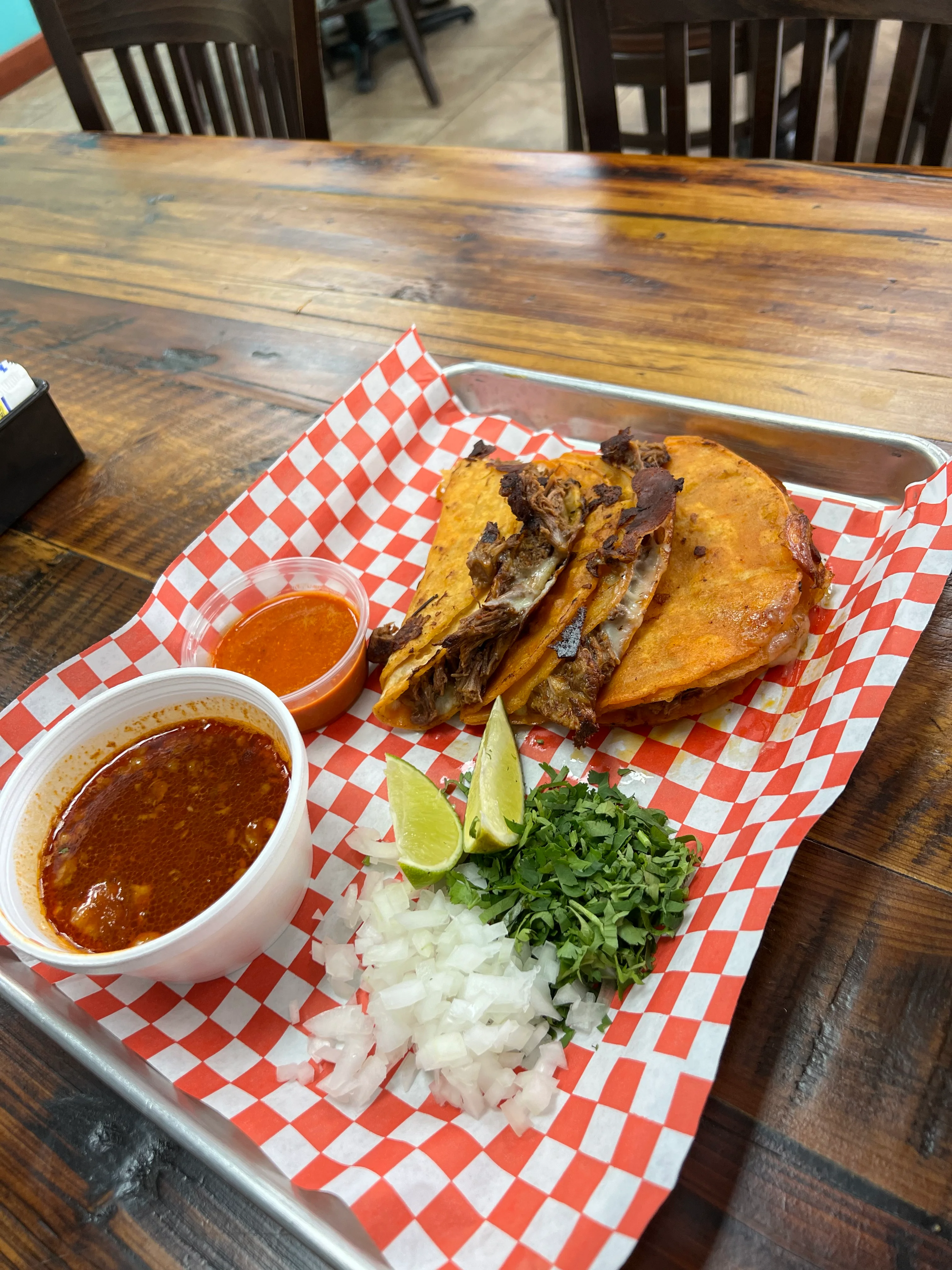 Delicious Mexican tacos with consomé and fresh toppings