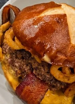 Juicy American cheeseburger with crispy bacon and onion rings