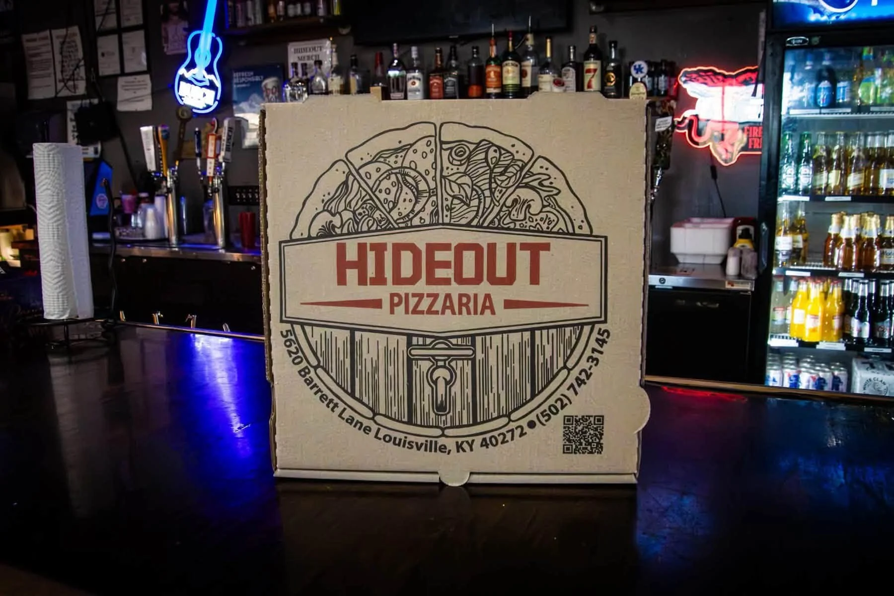 Pizzeria pizza box displayed at a lively restaurant bar