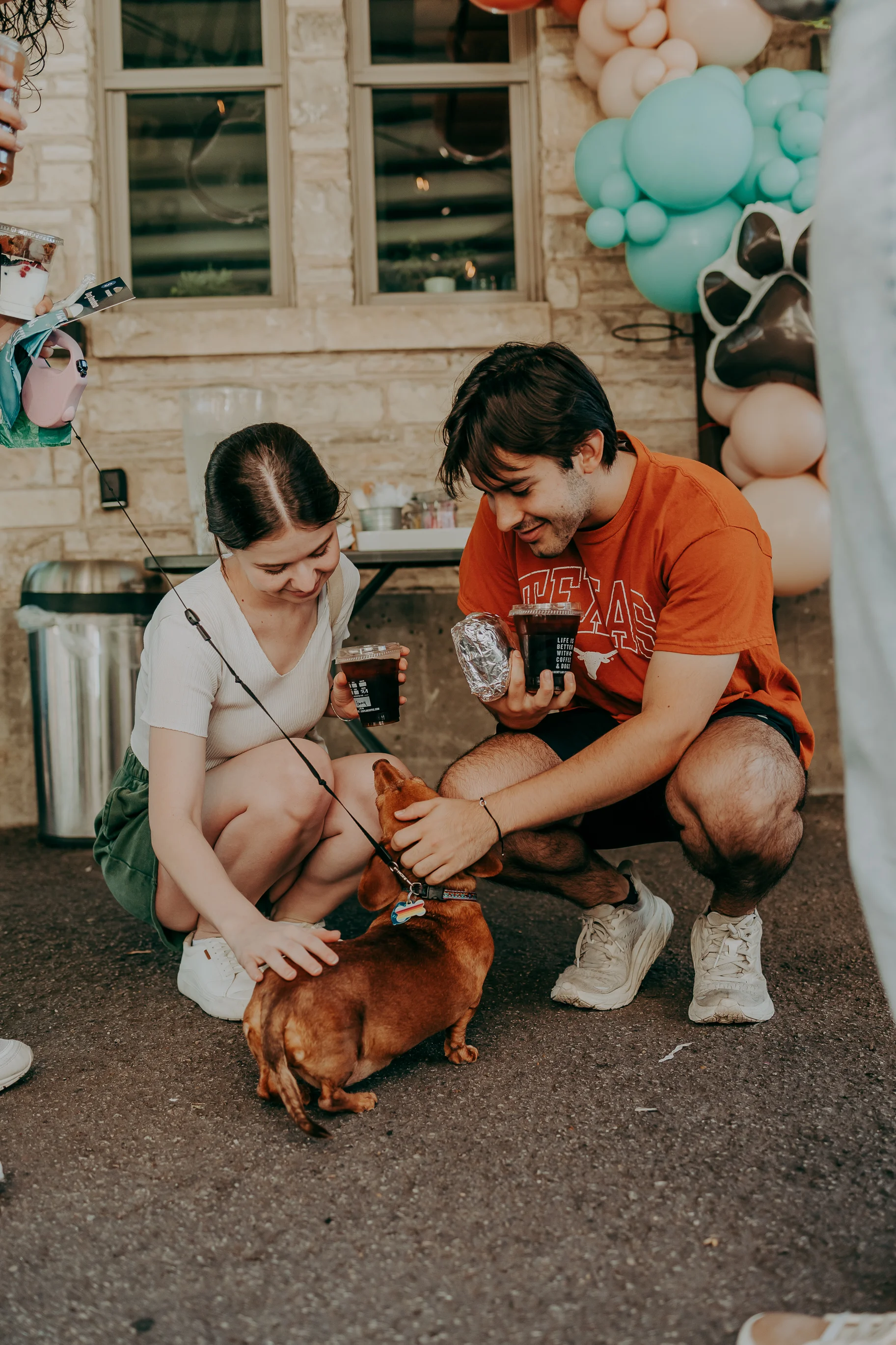 Couple enjoying time with a dog at a festive outdoor gathering