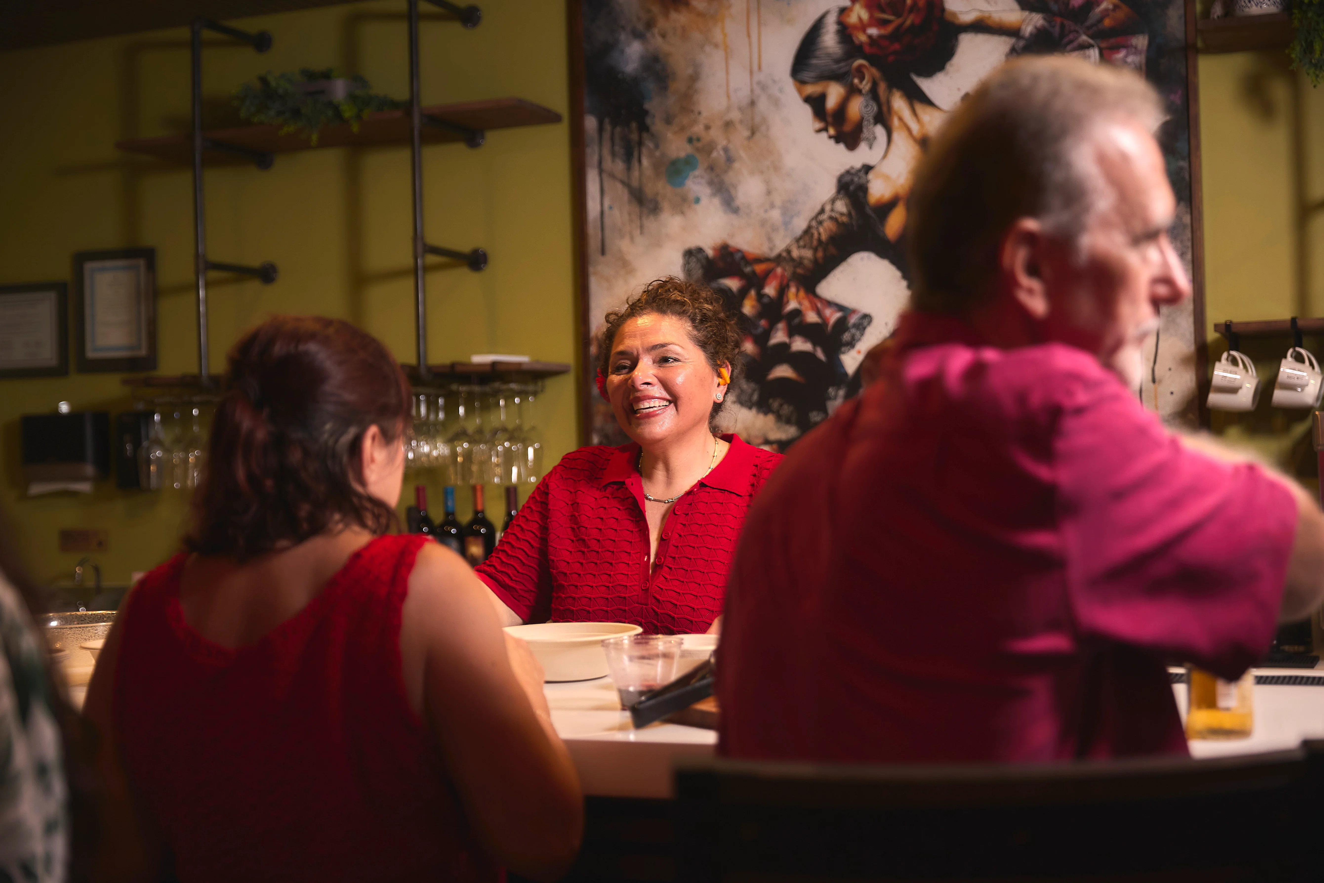 Warm restaurant atmosphere with smiling staff and guests