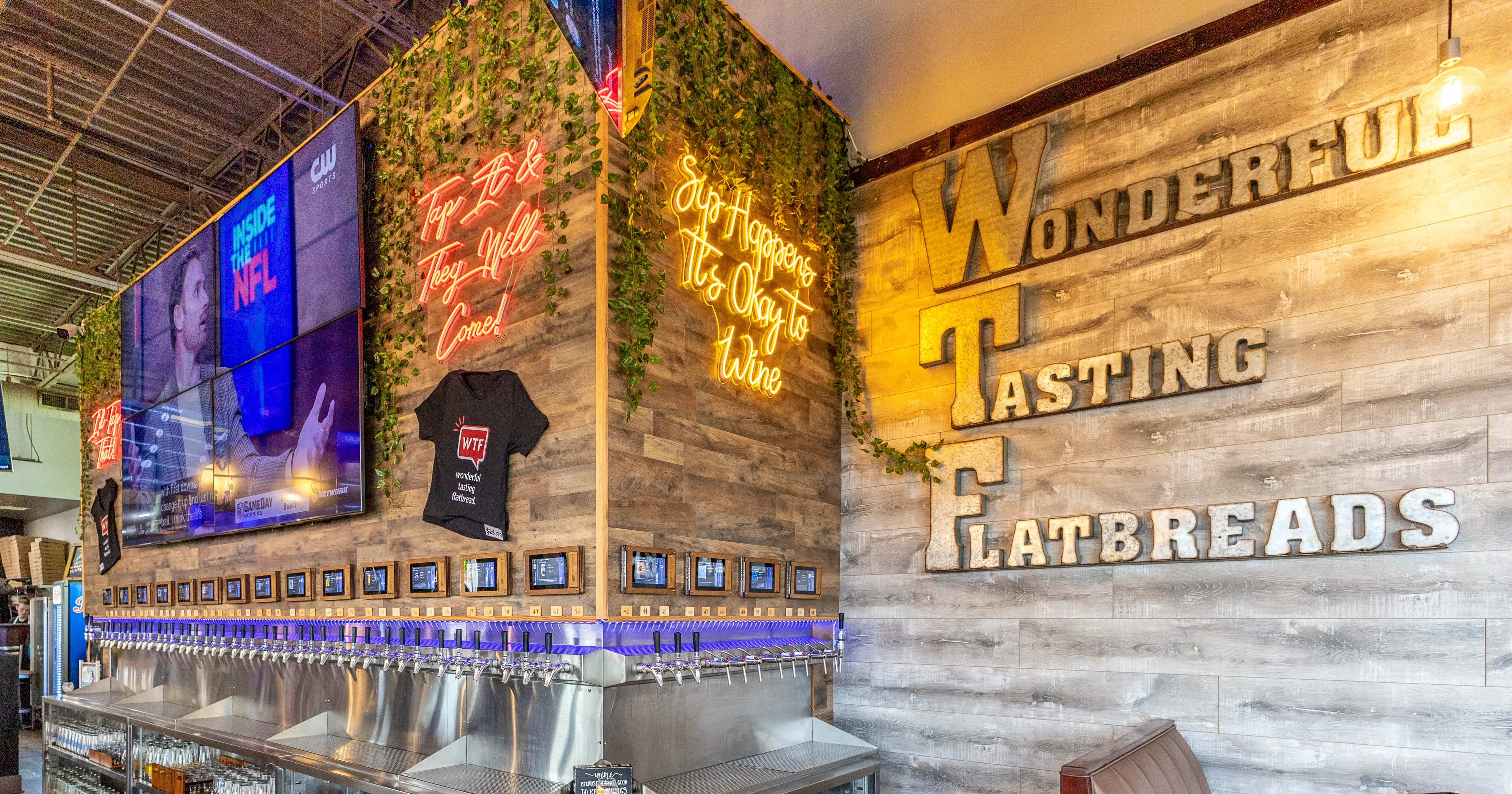 Modern bar with multiple beer taps and sports screens