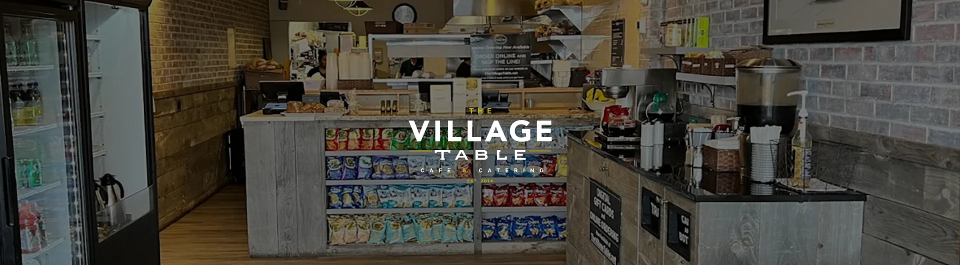 Interior view of Village Table cafe with food and drink displays.