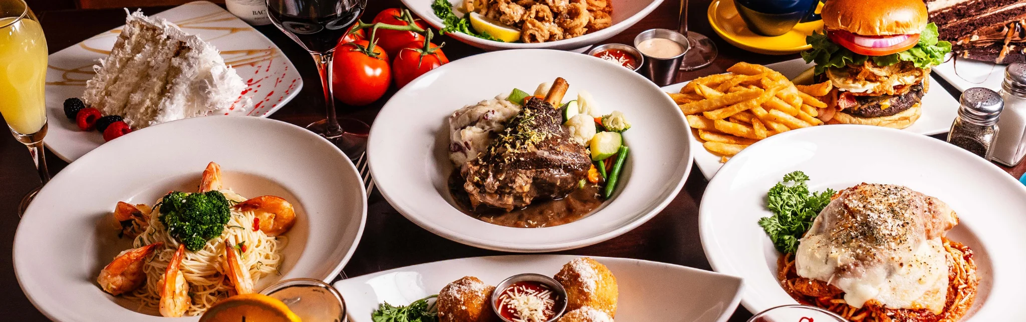Assorted gourmet dishes including pasta and burger in a vibrant restaurant setting