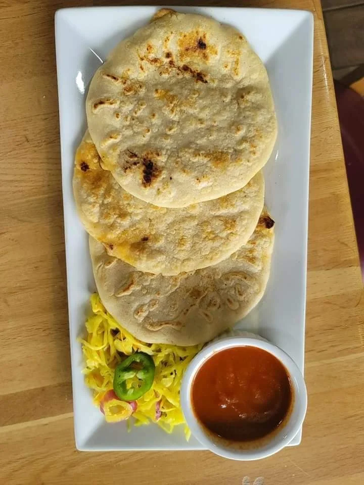 Pupusas served with curtido and salsa roja