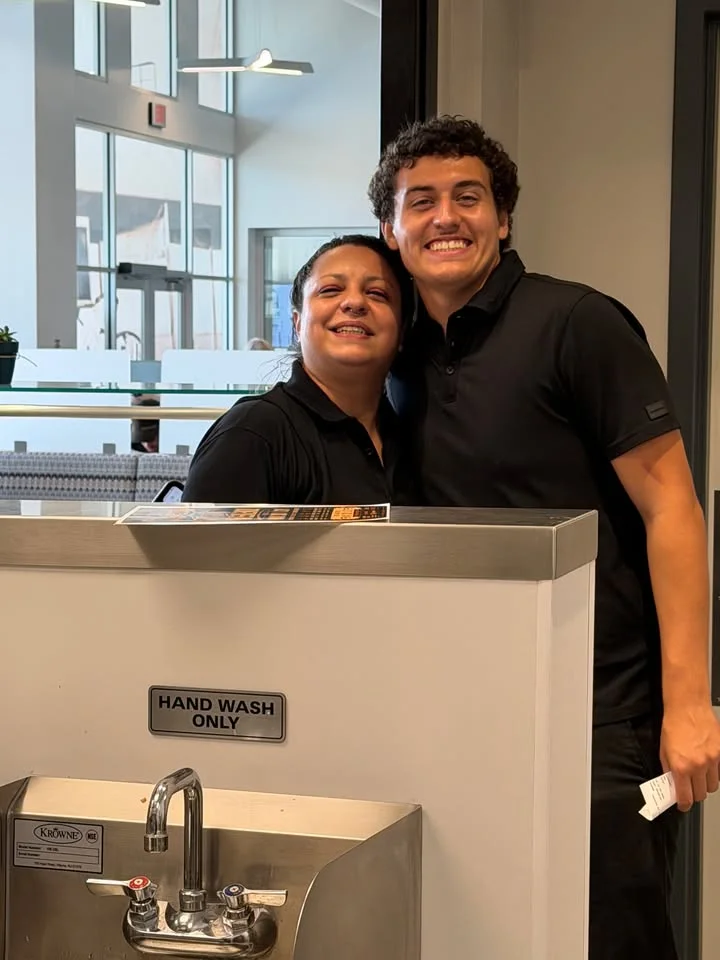 Two restaurant staff members smiling in a modern dining area