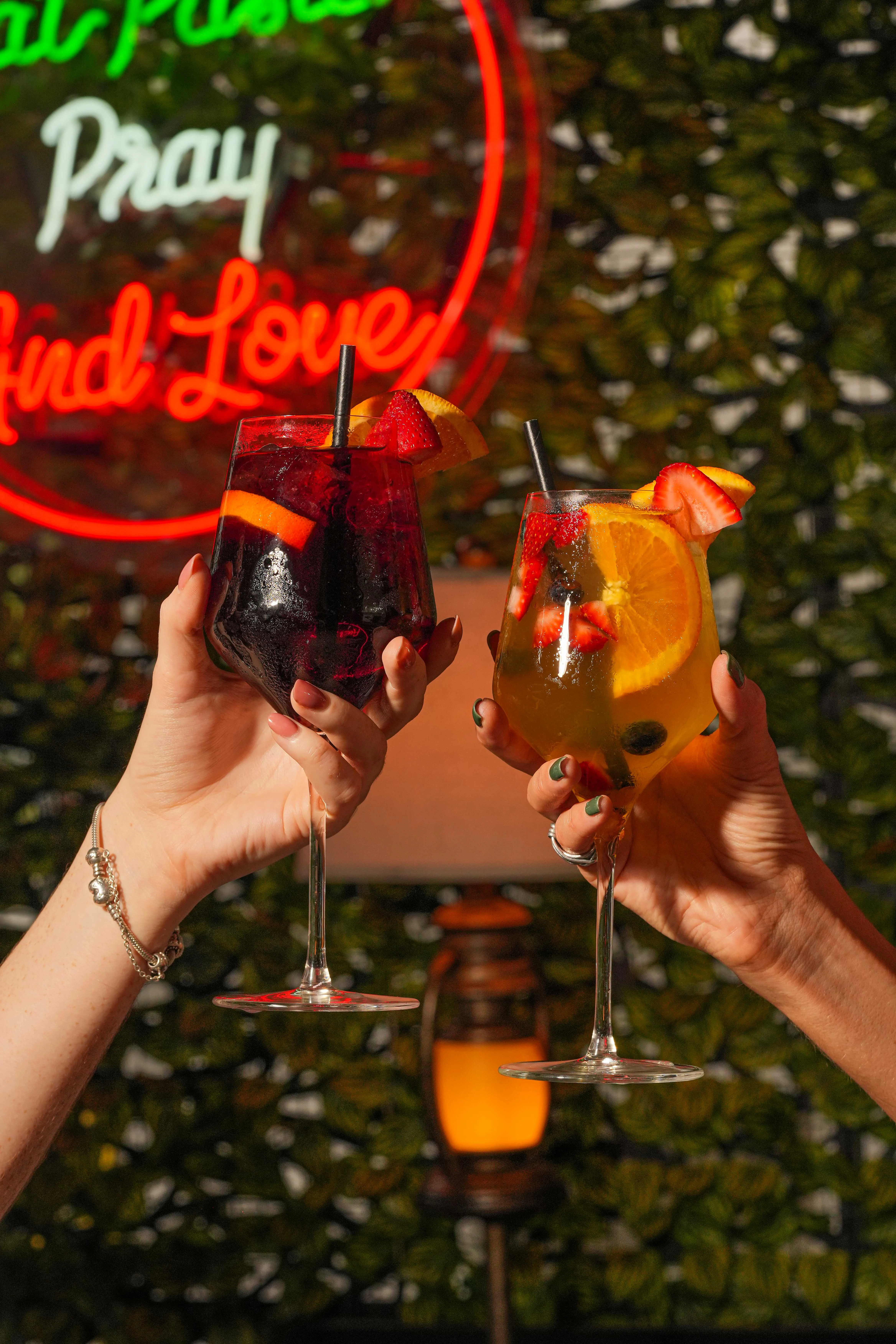 Colorful cocktails clinking in celebration at a vibrant bar