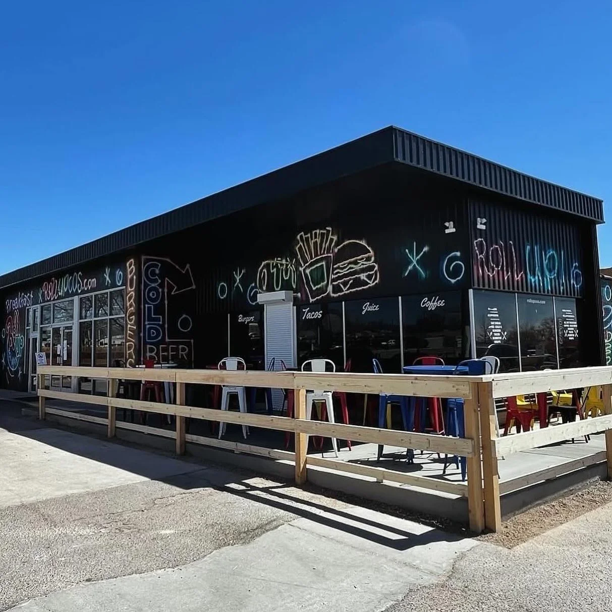 Colorful restaurant exterior with outdoor seating and vibrant murals