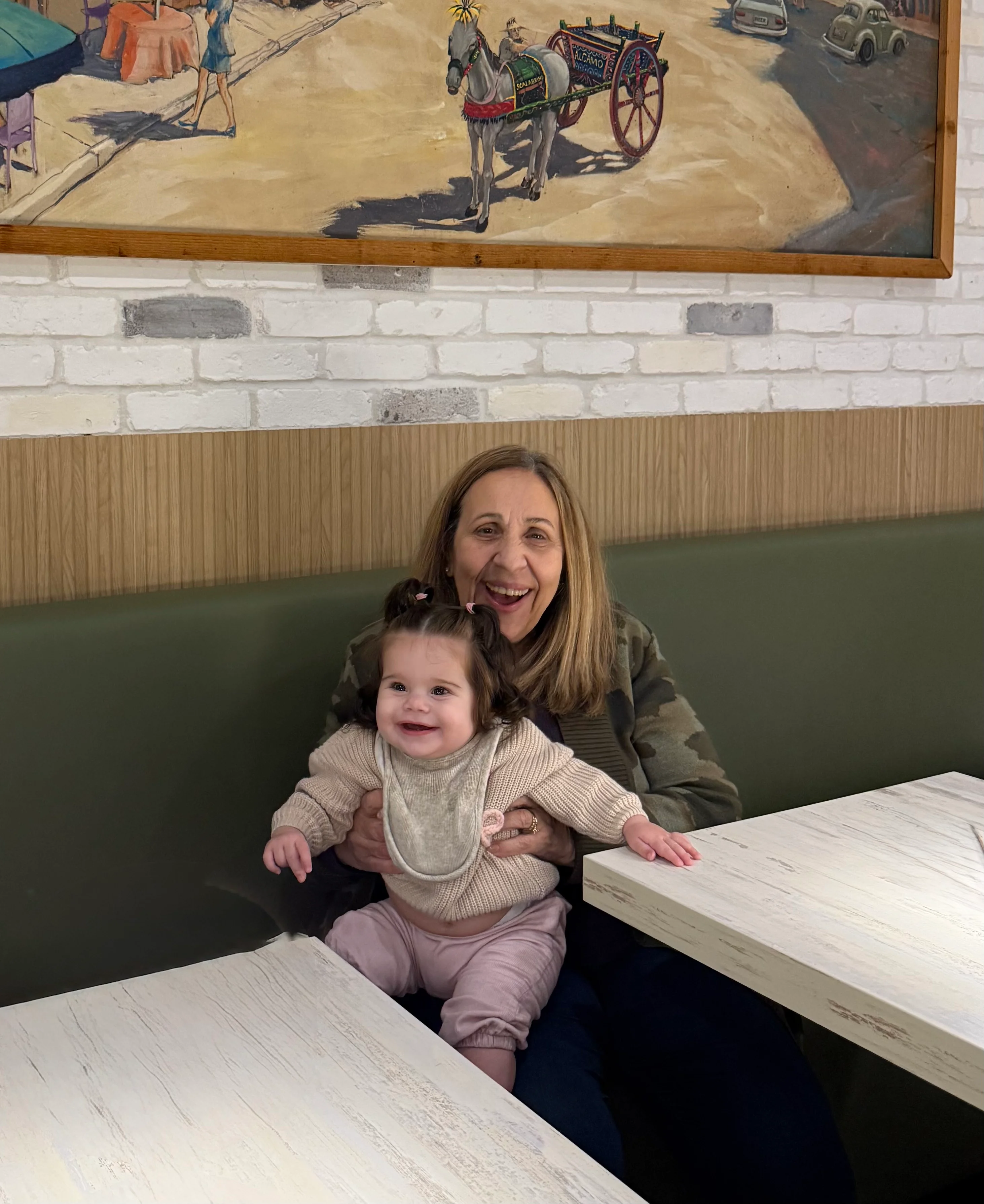 Happy grandmother and baby enjoying time together in a cozy restaurant