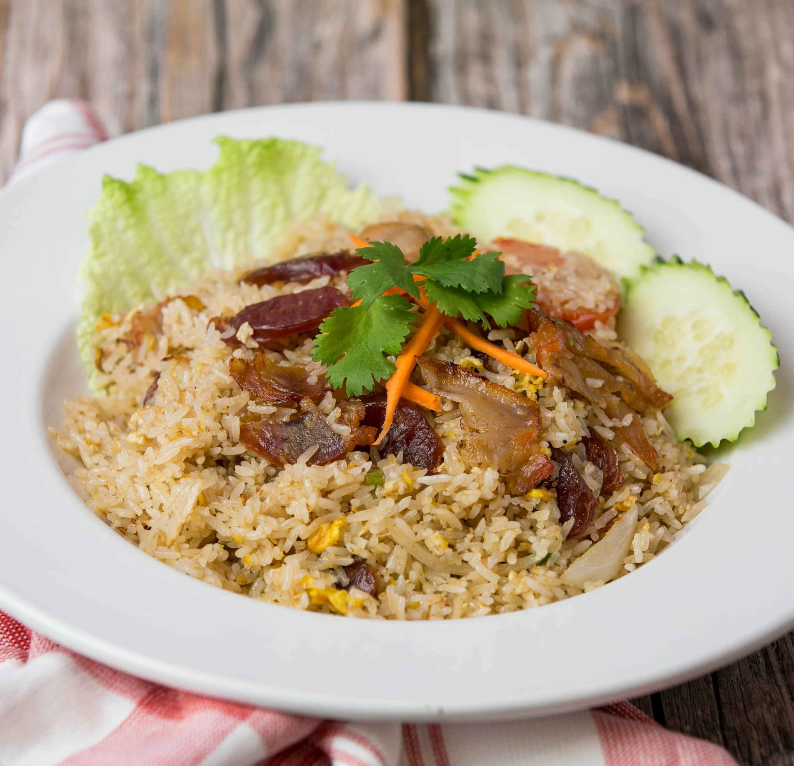 Plate of Malaysian Nasi Goreng with vegetables and garnishes
