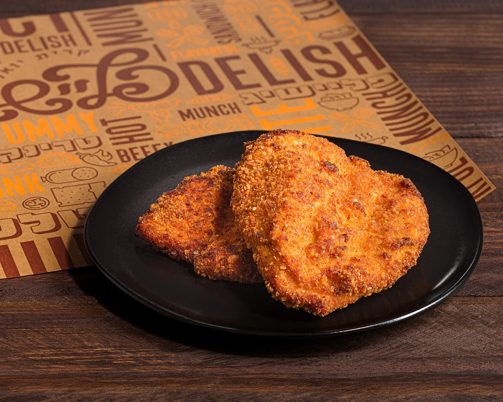 Crispy fried chicken cutlets on a black plate