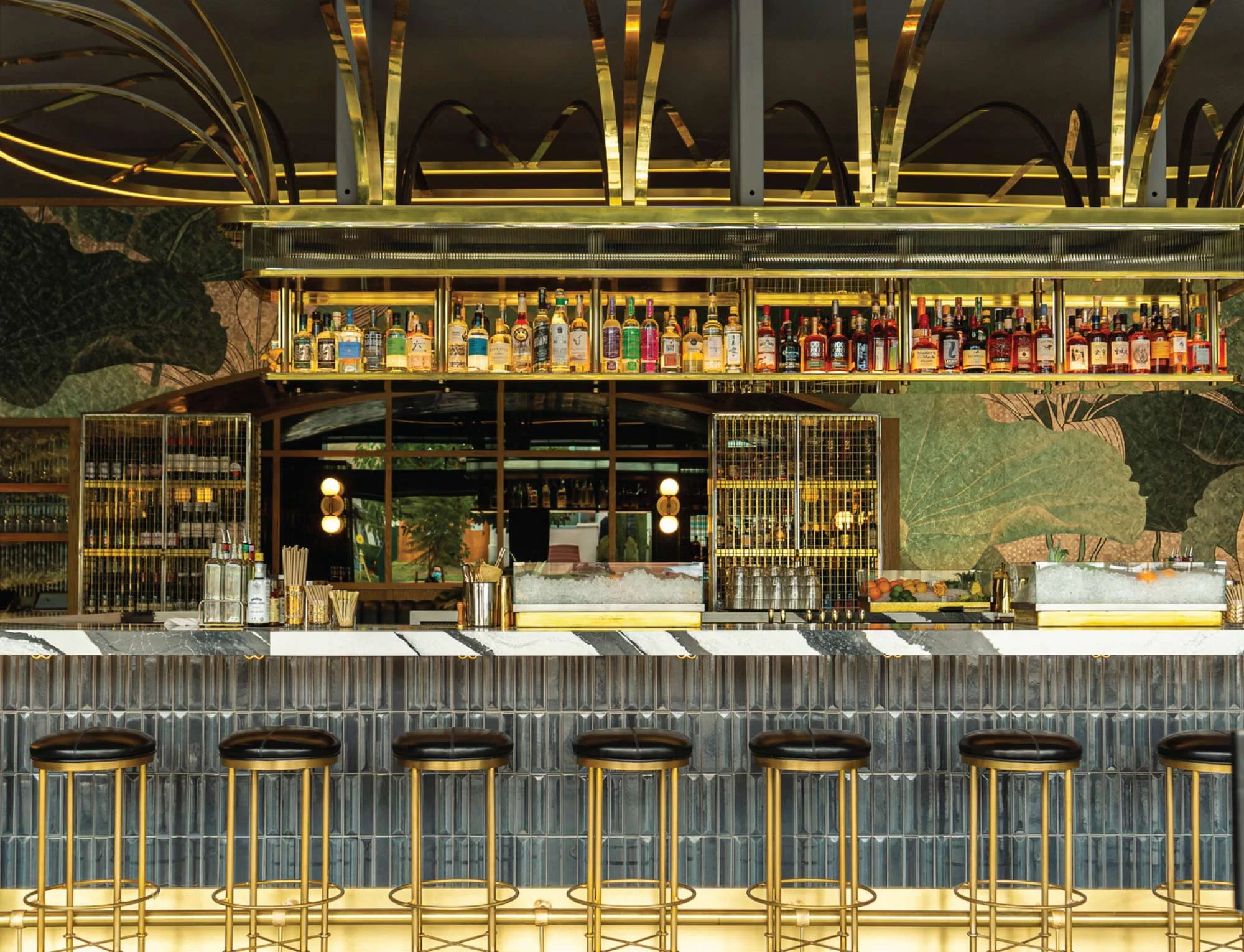 Kingfisher Bar with gold barstools and liquor display.