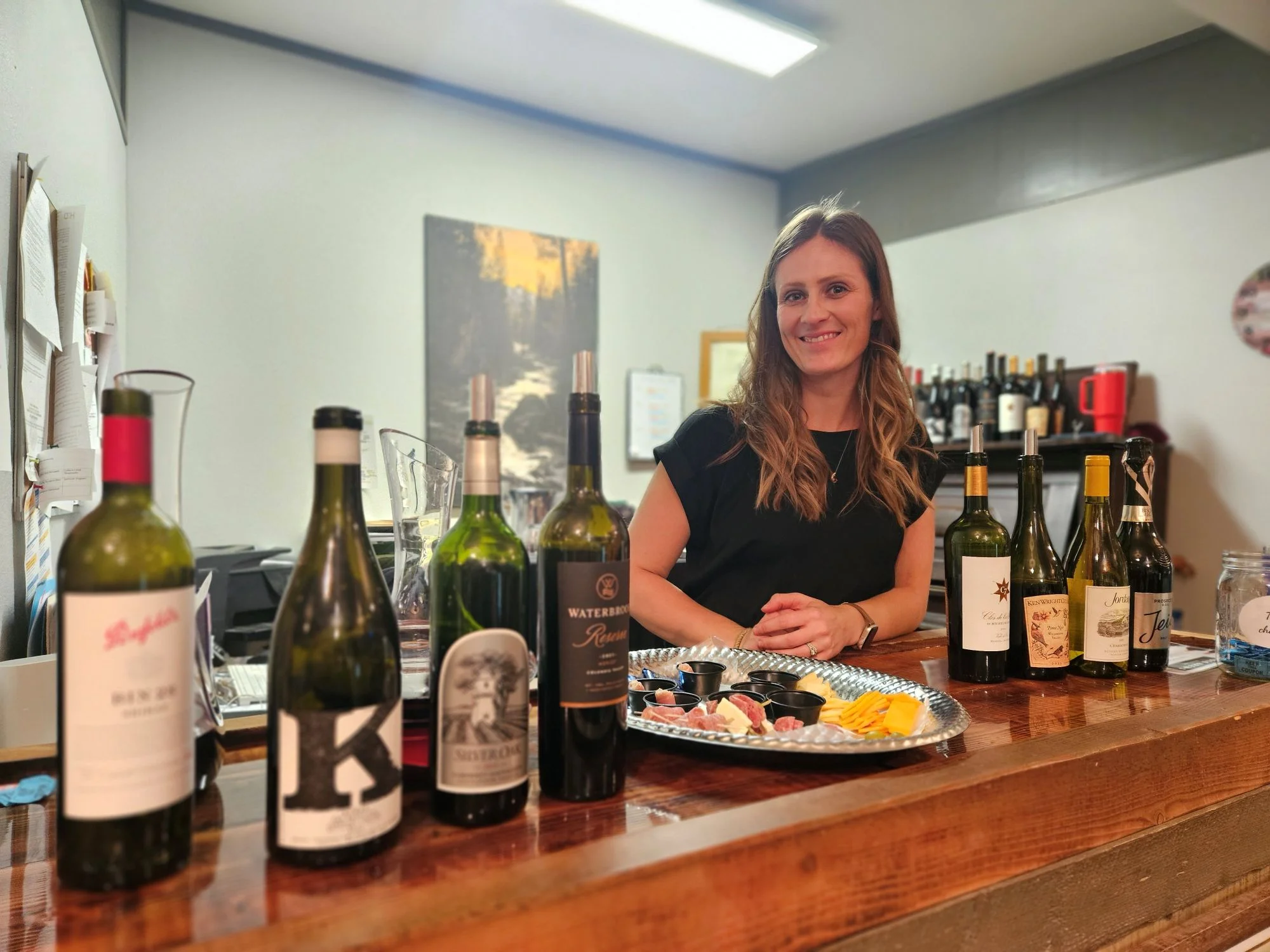 Wine tasting setup with assorted bottles and cheese platter