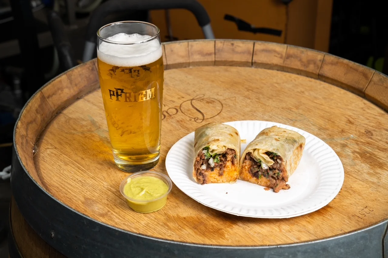 Delicious burrito with beans and rice served with a cold beer