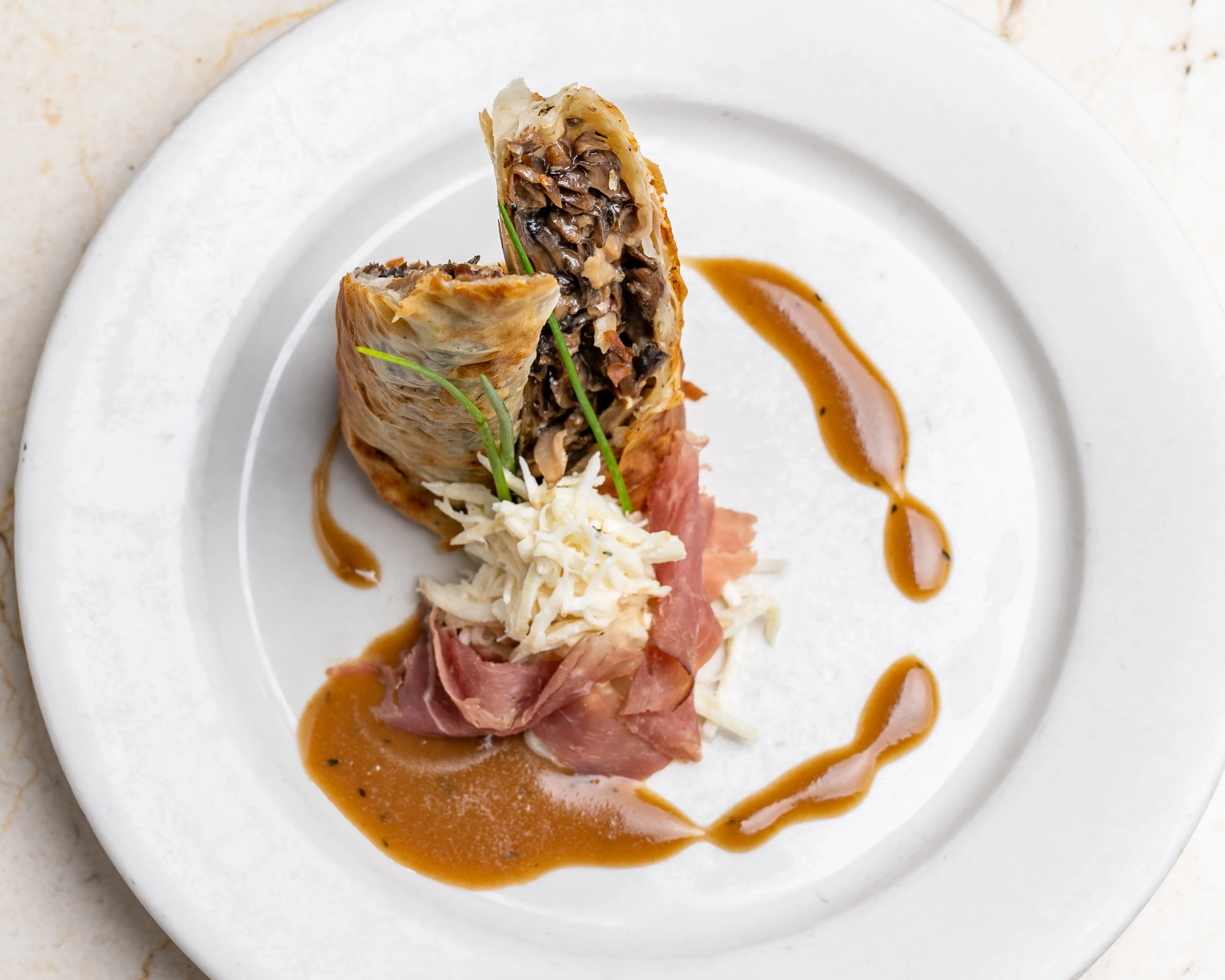 Chef presenting gourmet brunch dishes outdoors