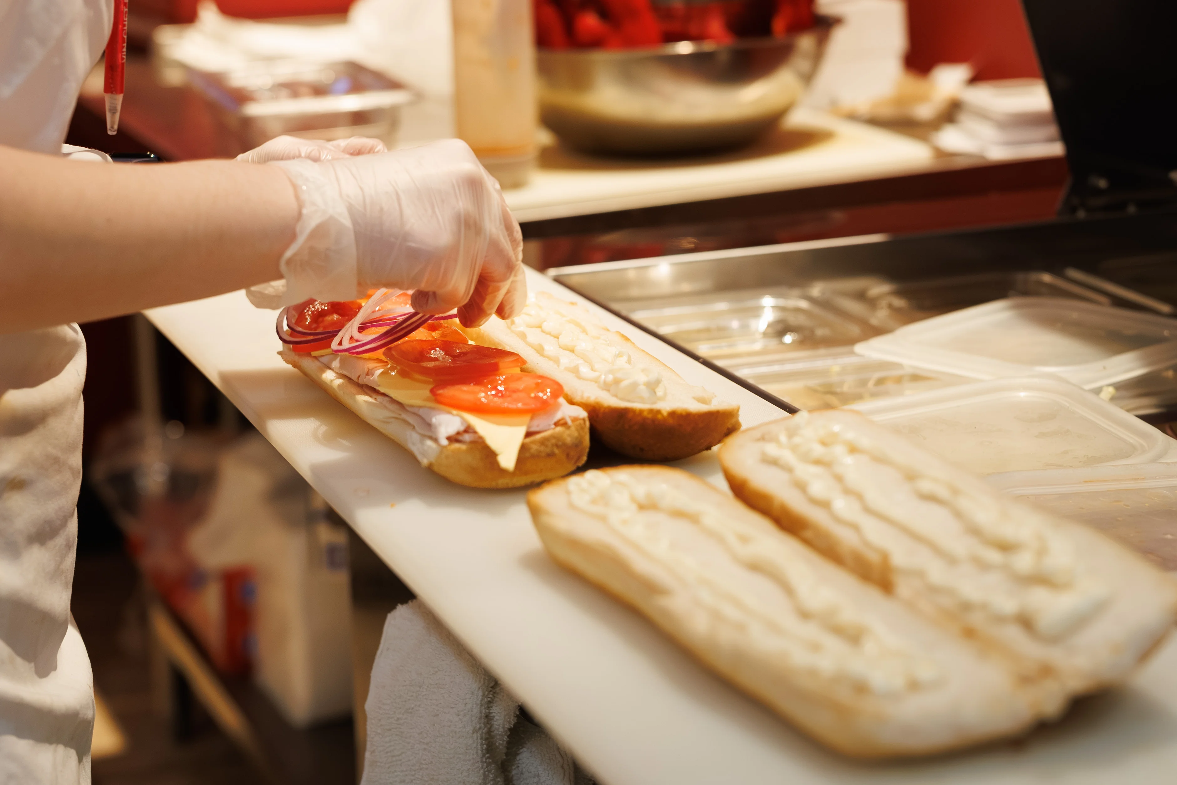 Submarine sandwich being prepared with fresh ingredients