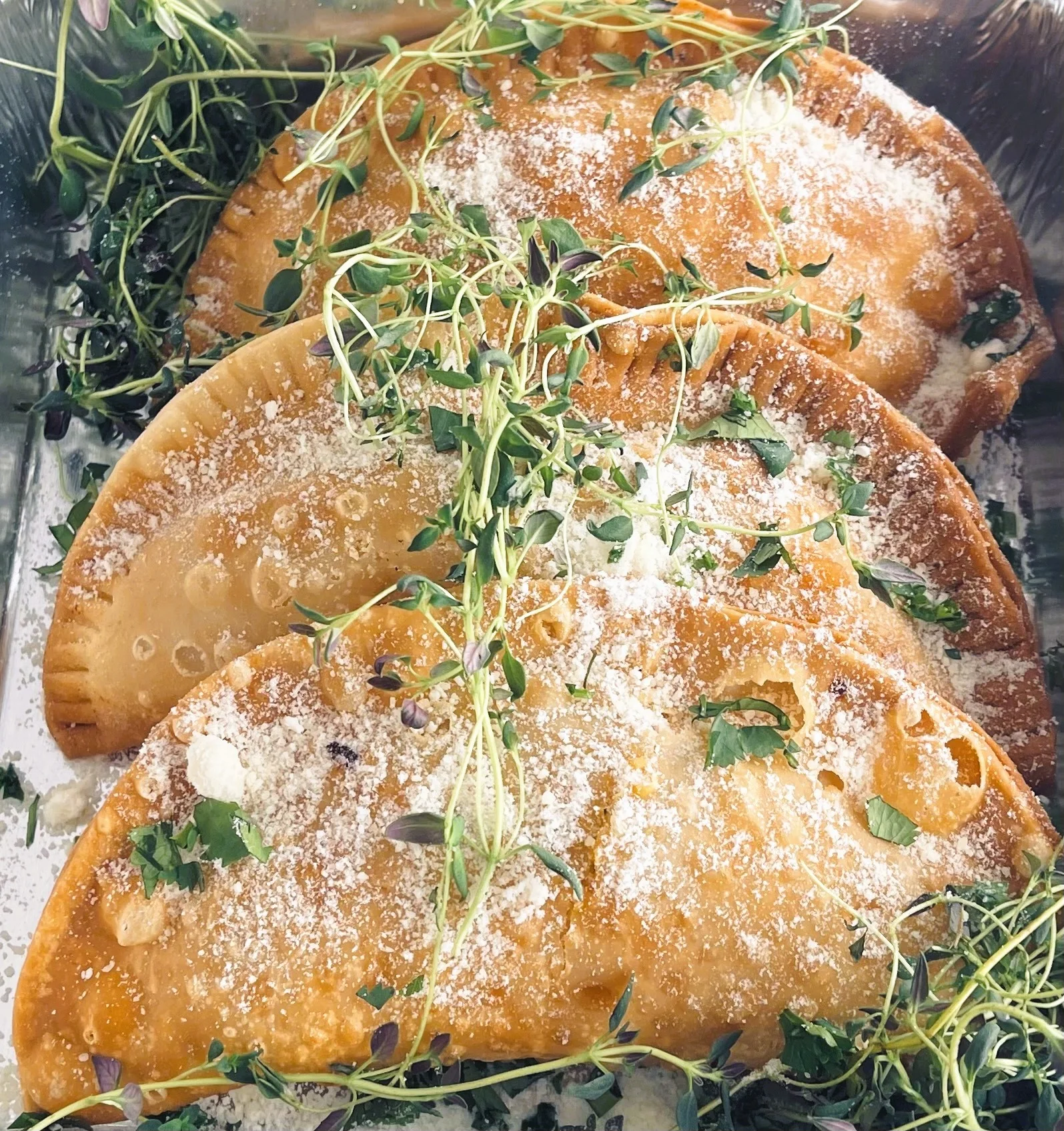 Delicious empanadas served on a wooden platter with dipping sauces.