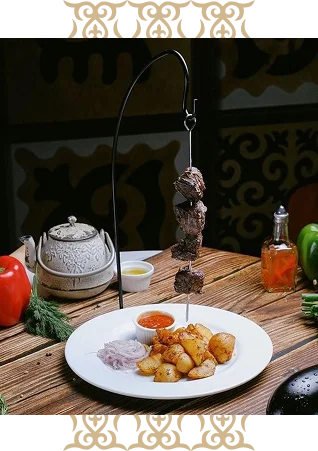 Skewered kebab served with roasted potatoes and dipping sauce