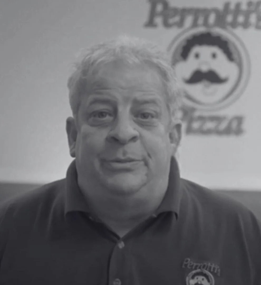 Owner of Perrotti's Pizza in a cozy restaurant setting