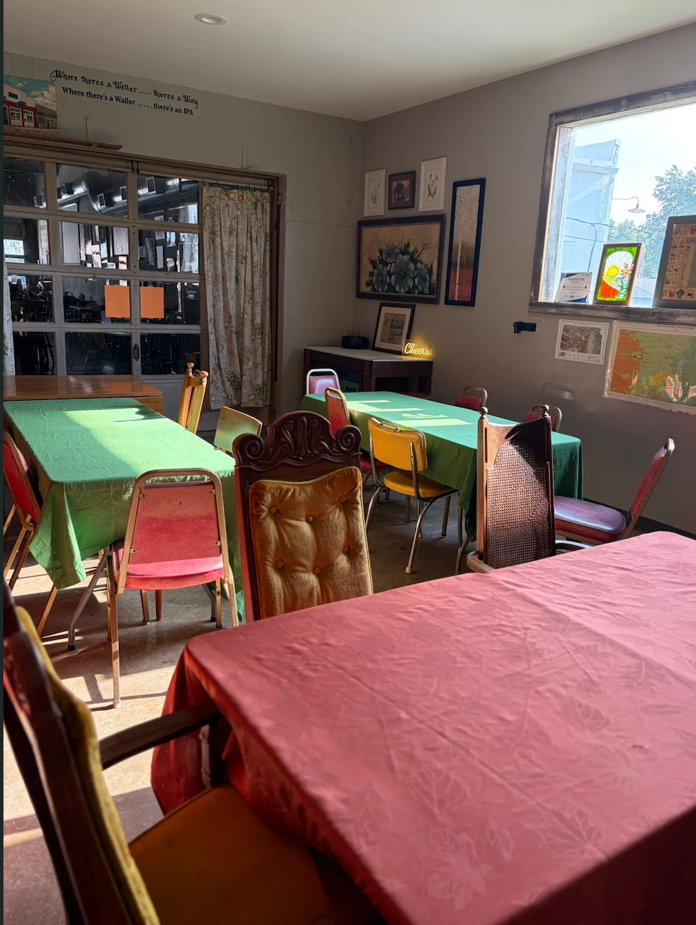 Eclectic restaurant dining room with colorful tablecloths and vintage chairs