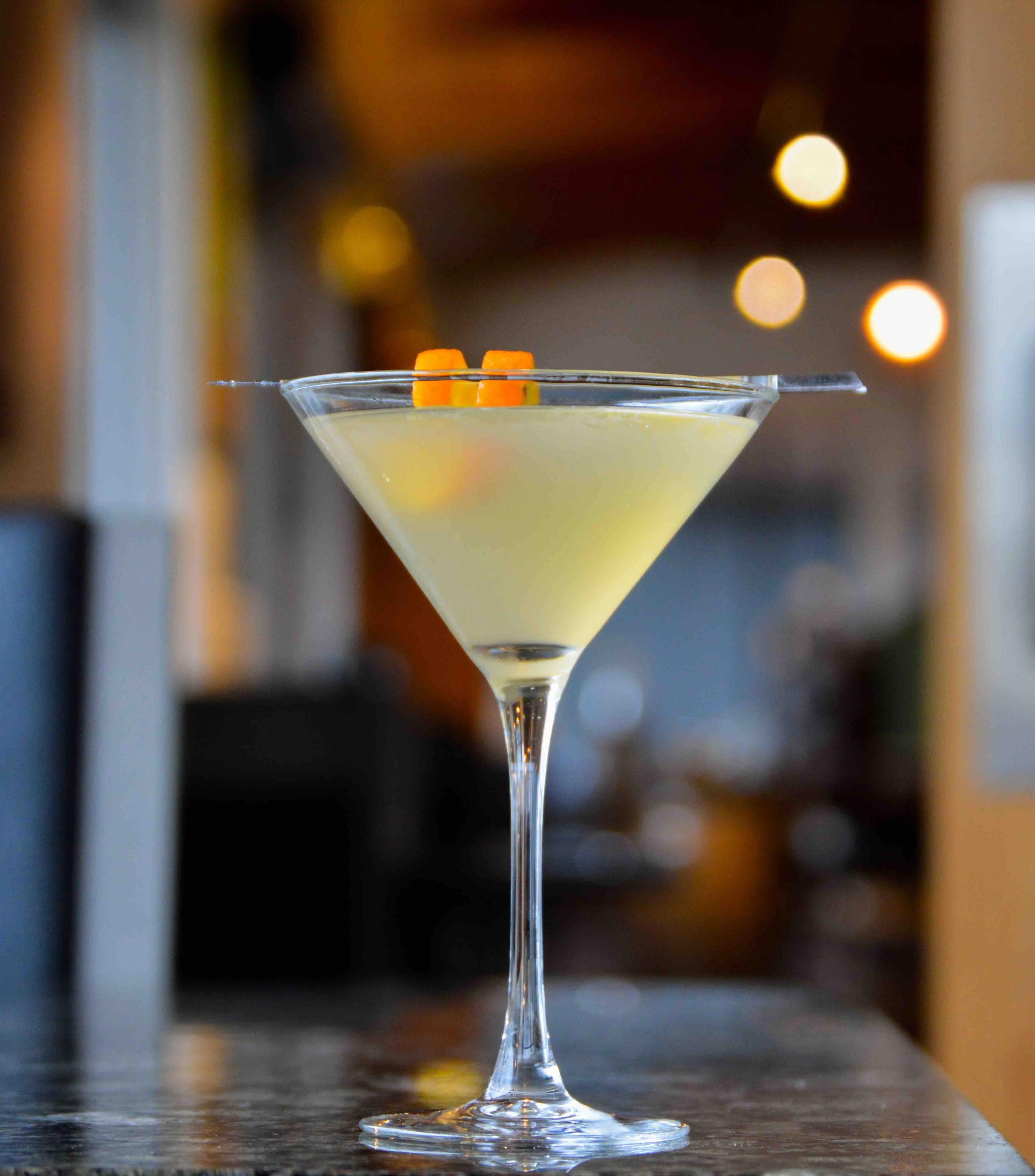 Twisted Oak Martini with sparkling yellow lights behind