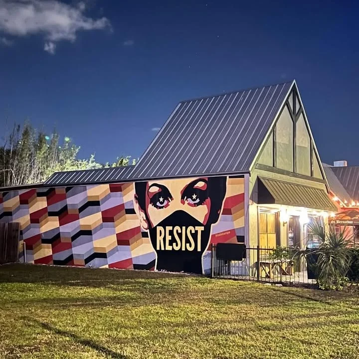 Colorful mural on restaurant exterior featuring the word 'RESIST'