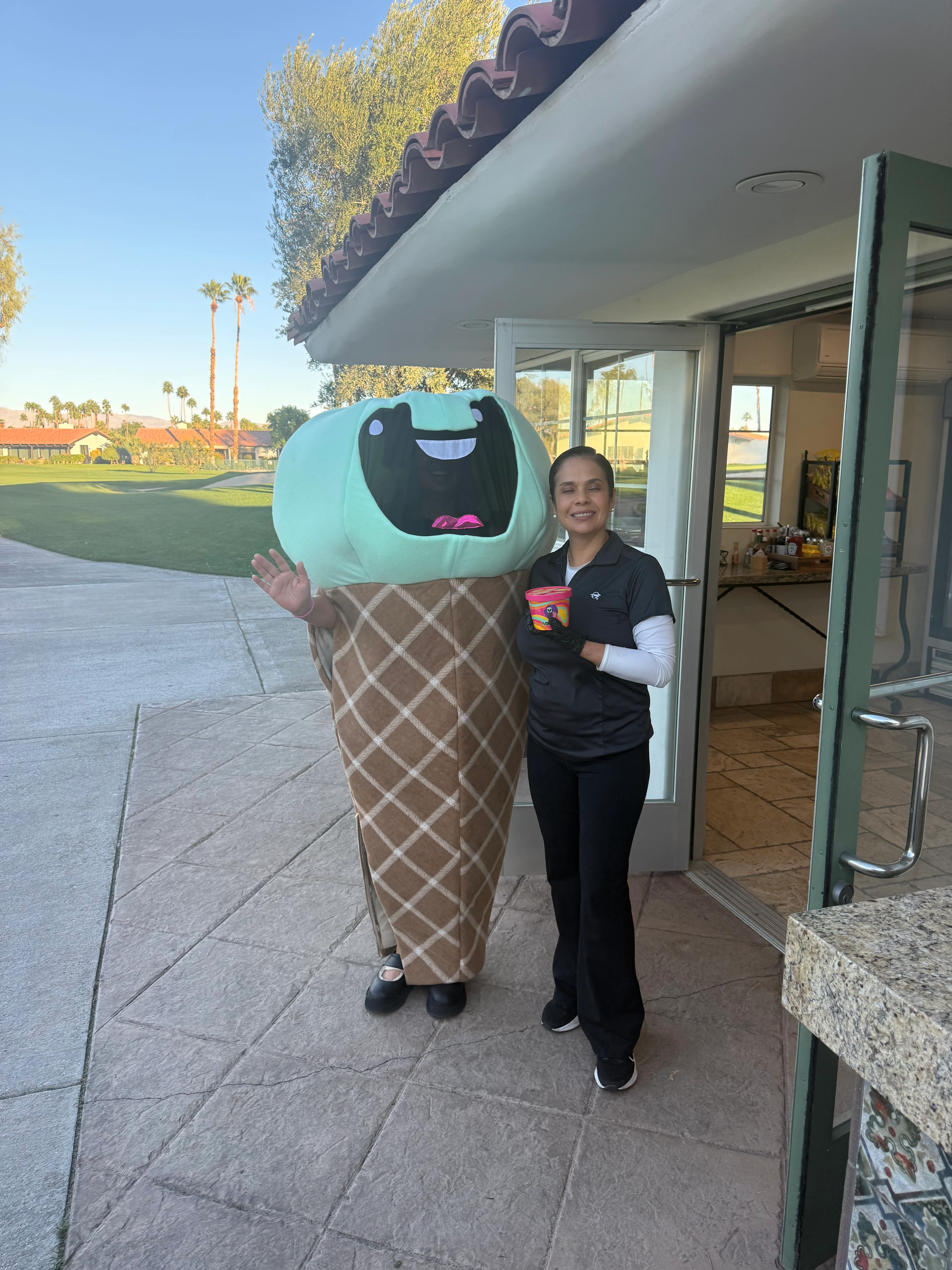 Fun ice cream mascot with staff member at a golf course