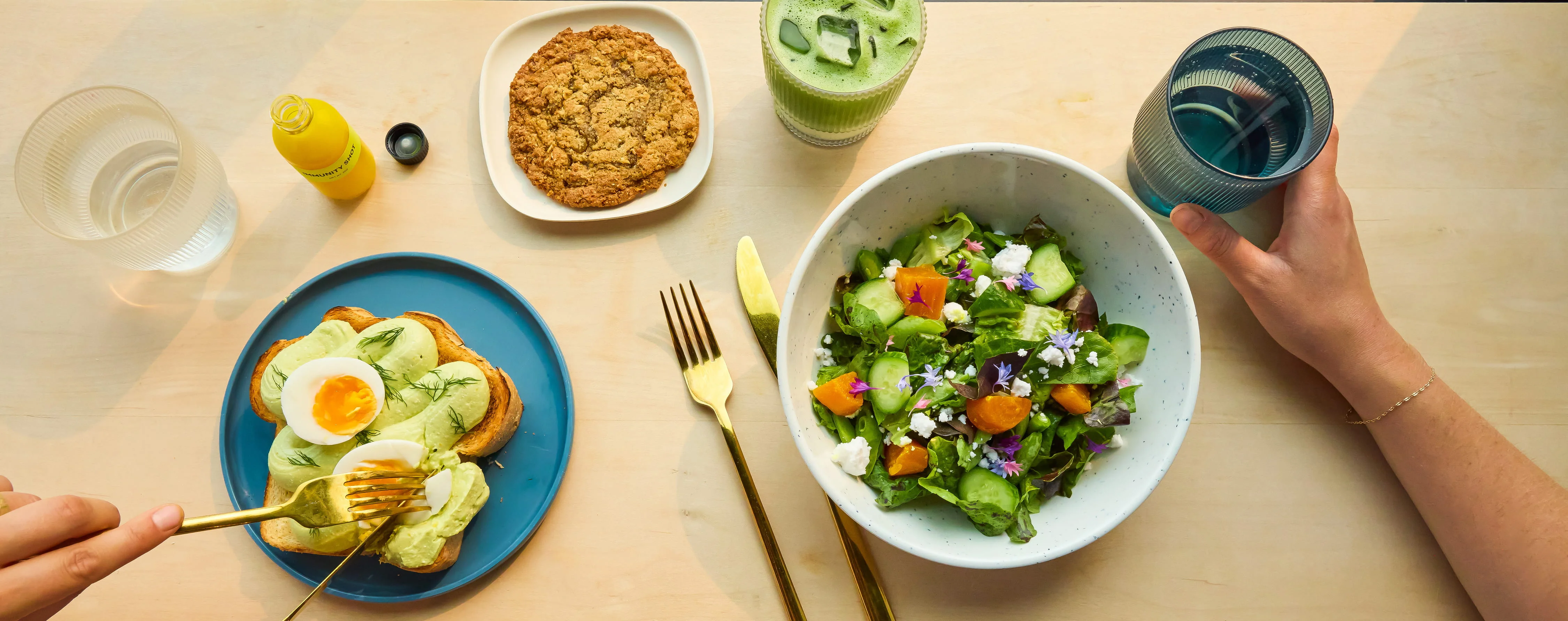 Avocado toast with soft-boiled egg and fresh salad on a wooden table