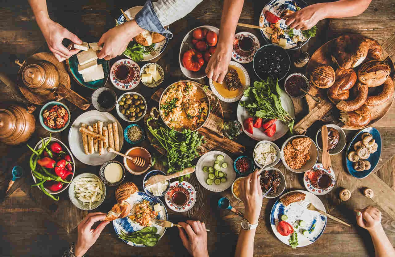 A vibrant spread of various dishes and drinks on a wooden table.