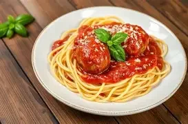 A delicious plate of spaghetti topped with fresh herbs and sauce.