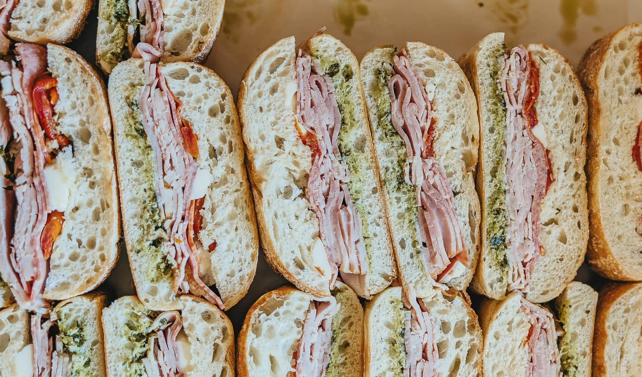 Italian sub sandwich with layers of meats and pesto on fresh bread