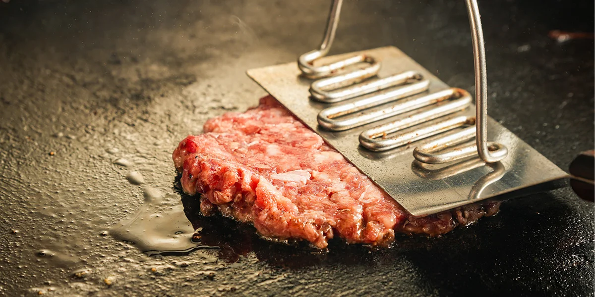 Grilling a juicy hamburger patty on a hot griddle