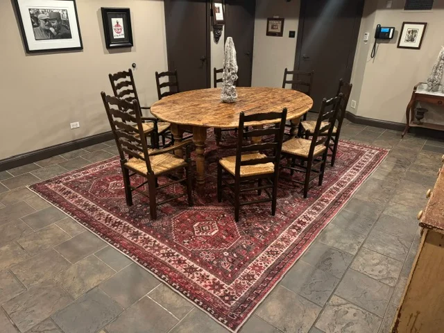 Rustic dining area with a round wooden table and six chairs